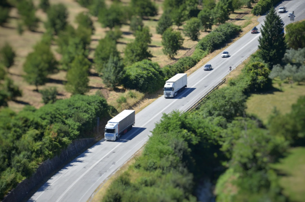 Camiones circulando por una carretera de doble sentido junto a más vehículos.