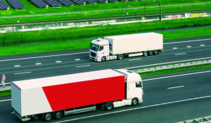 dos camiones eléctricos circulando por un entorno verde